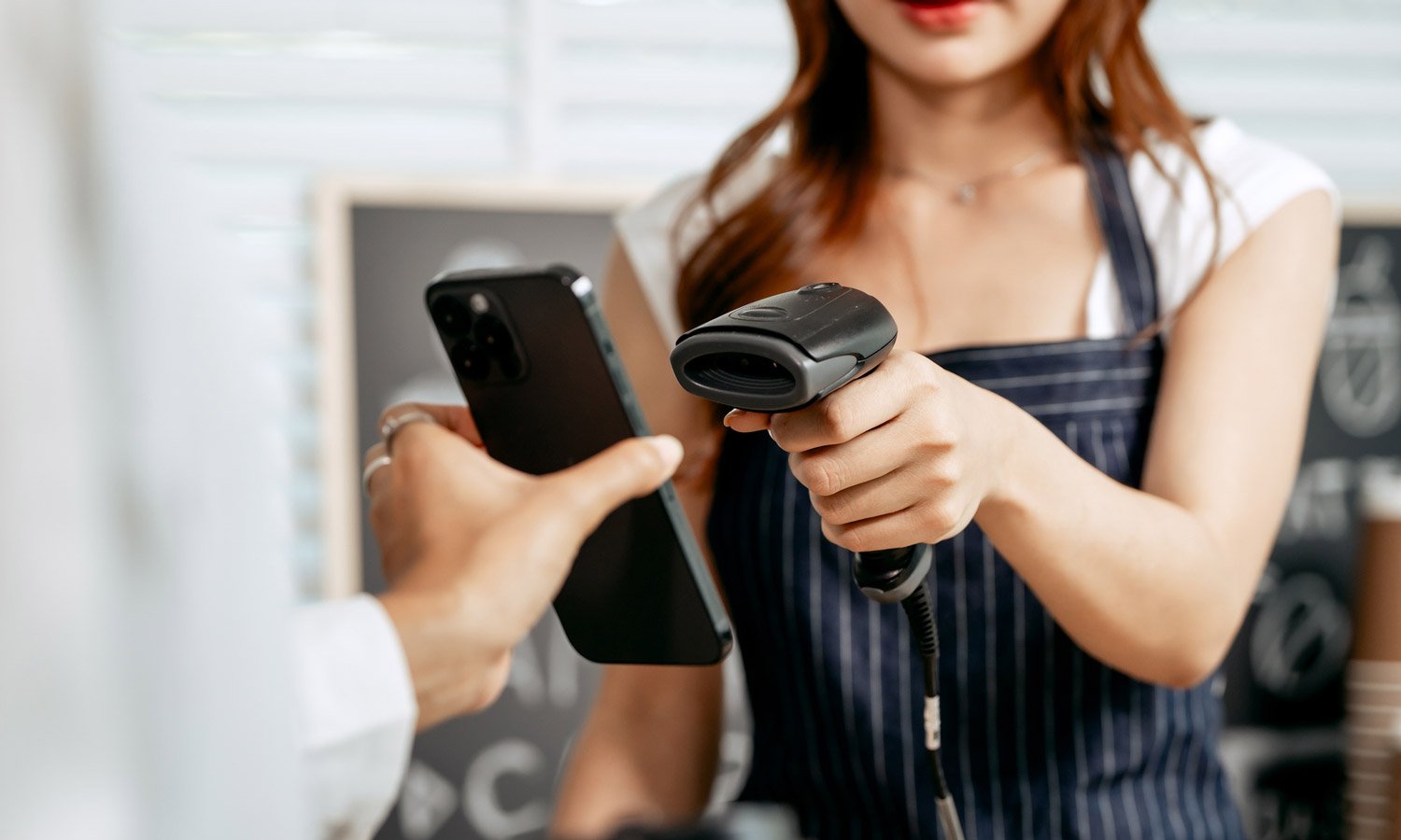 Une cliente s’identifie à la caisse en présentant sa carte de fidélité sur son appareil mobile.
