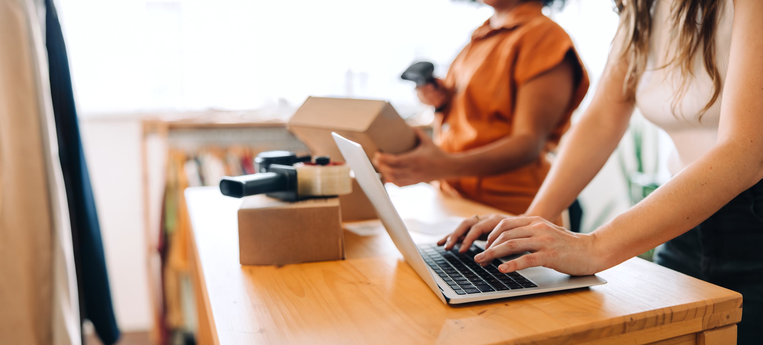 Two women entrepreneurs configure their online business at Shopify.