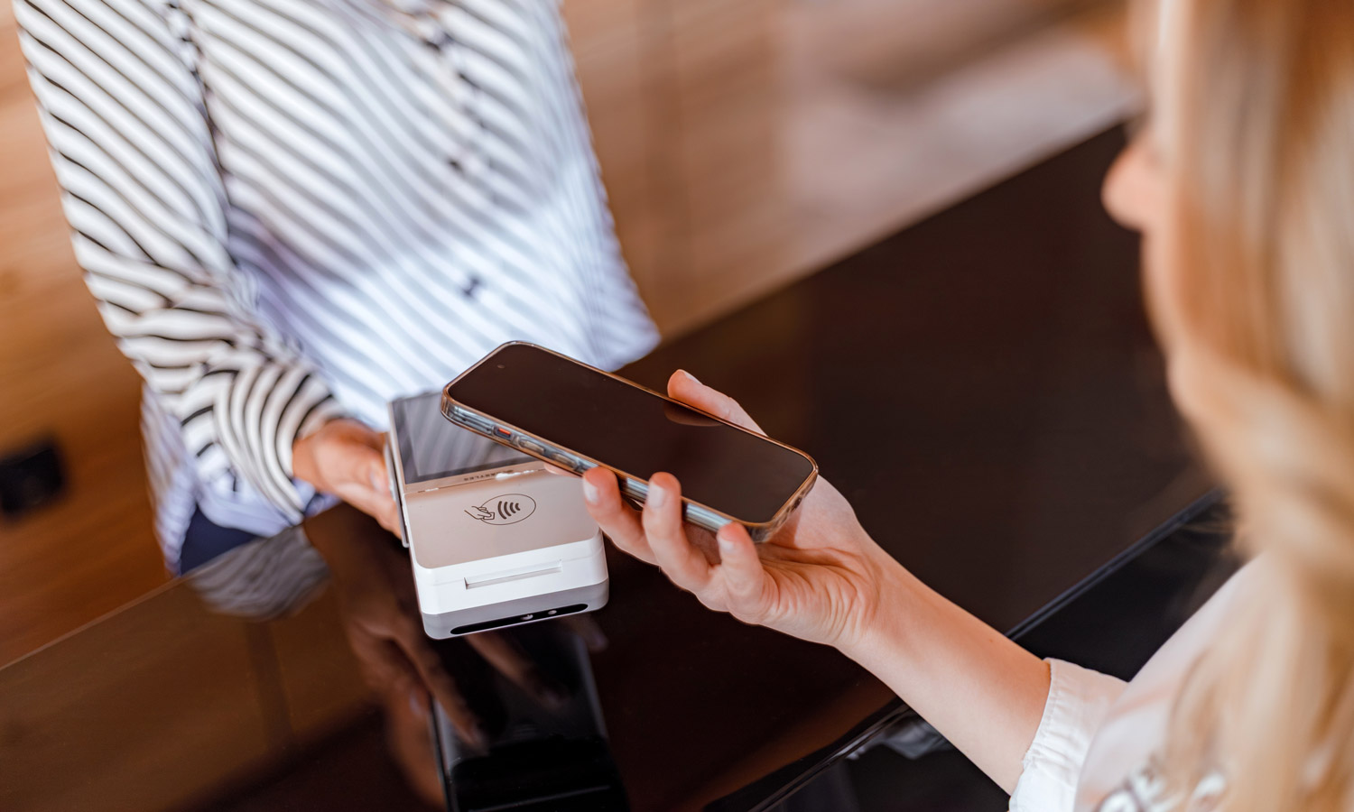 Une membre utilise l’application mobile d’un programme de fidélisation pour effectuer un paiement chez un détaillant